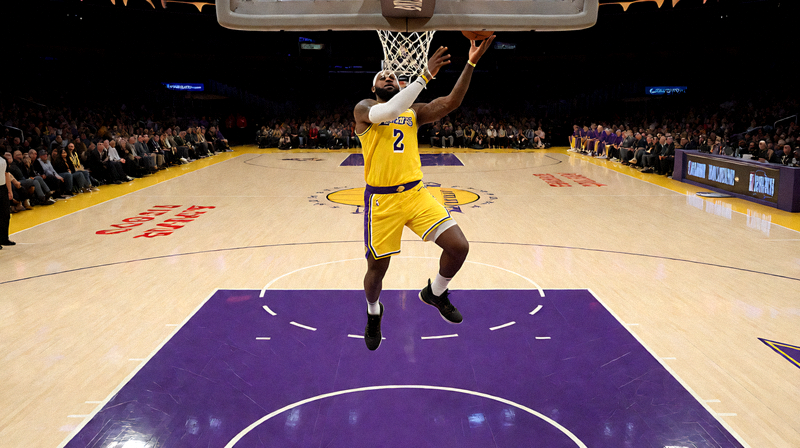 NBA比赛现场，洛杉矶湖人队主场斯台普斯中心，詹姆斯在比赛中上篮得分的瞬间