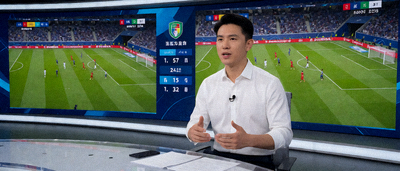 体育直播演播室中主持人进行现场解说，背景大屏幕显示实时比赛画面和数据统计